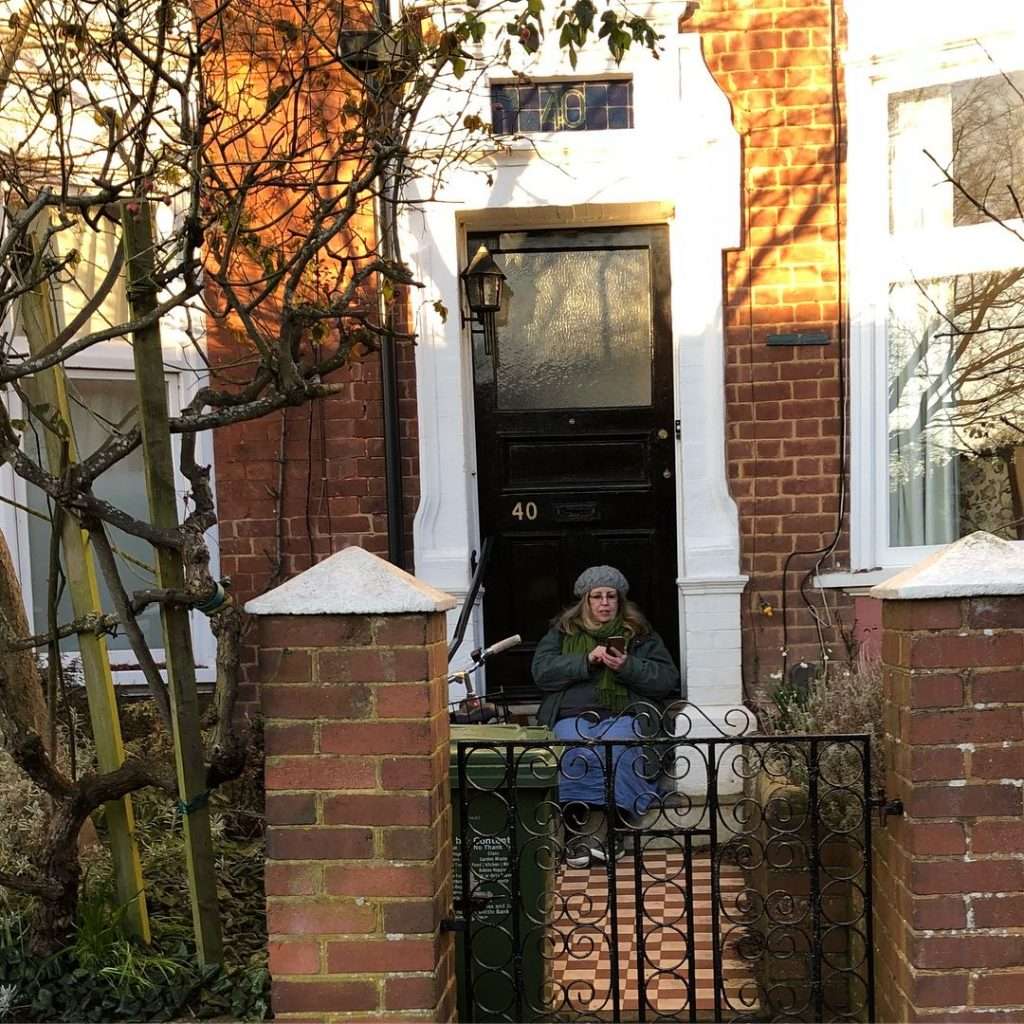 Woman locked out sitting on doorstep waiting for a locksmith